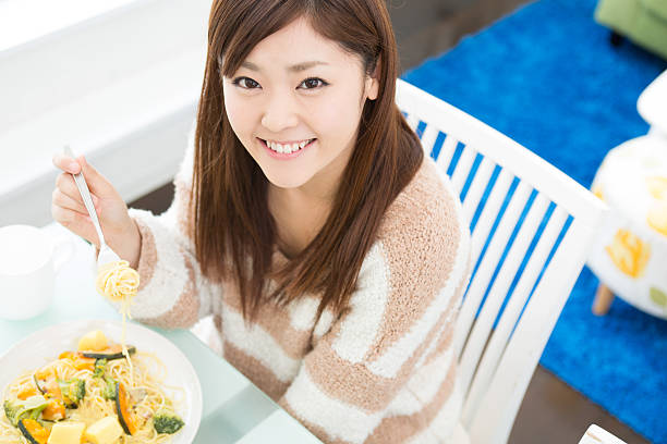 istock young attractive asian woman who  eats 603903350