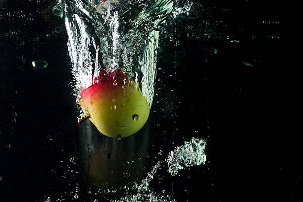 istock Apples in water on a black background 603904576