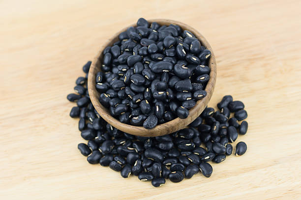 istock Black beans on wooden background 603905642