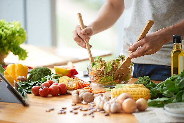 Vegetable salad Vegetarian man mixing vegetable salad in bowl salad photos stock pictures, royalty-free photos & images