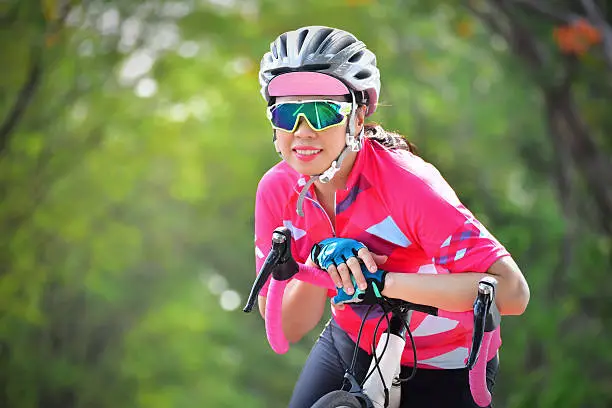 Photo of Woman ride bike on countryside with tree tunnel