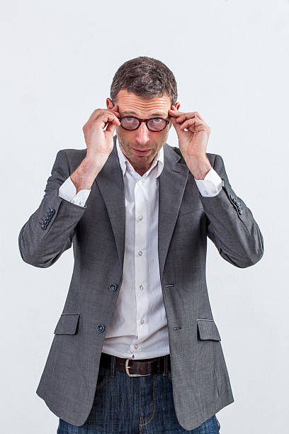 pensando empresário de meia-idade ajustando seus óculos para ler - glasses personal perspective the bigger picture men - fotografias e filmes do acervo
