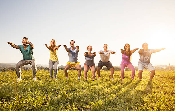 istock Smiling group of people doing squats and exercising in nature. 603986210