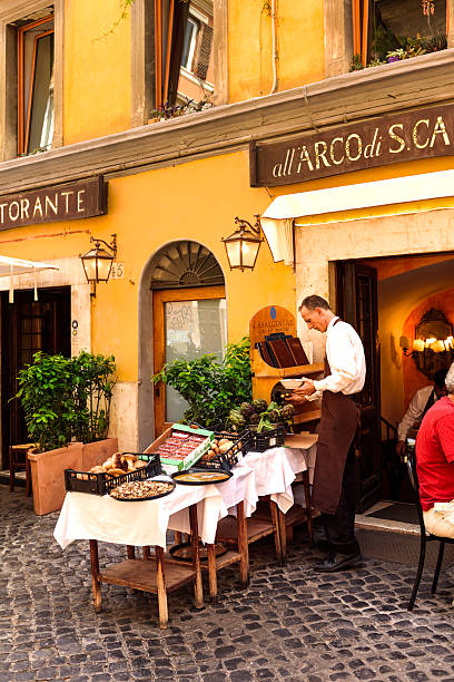 People dine on a restaurant patio in downtown Rome, Italy on a sunny day.