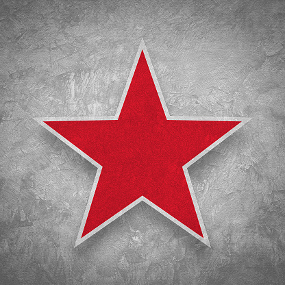 Red star on grunge concrete wall background.
