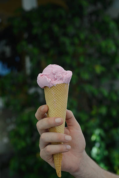 istock Hand holding pink ice-cream 603989998