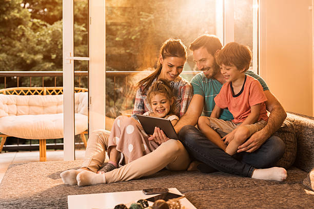 istock Happy family using digital tablet in the living room. 603990794