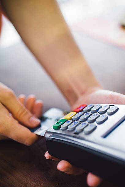istock Female hand inserts the credit card into the terminal 603992580