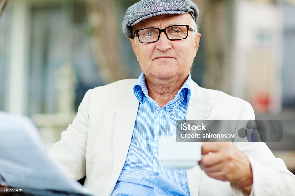 Morning coffee Portrait of senior man with newspaper and cup Adult Stock Photo