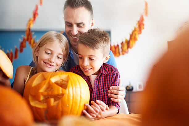 istock Father and offsprings over halloween pumpkin 603994168