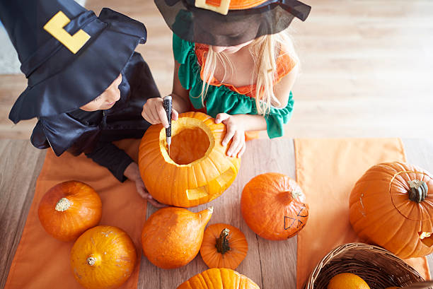 Children carving from the pumpkin Children carving from the pumpkin carving craft activity stock pictures, royalty-free photos & images
