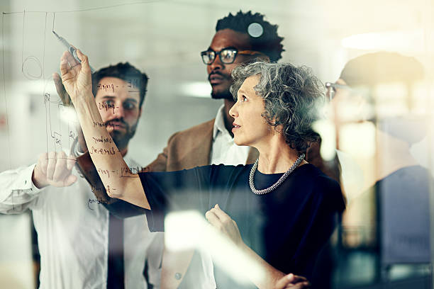 They never fall short of big ideas Cropped shot of a group of businesspeople brainstorming with notes on a glass wall in an office never stock pictures, royalty-free photos & images