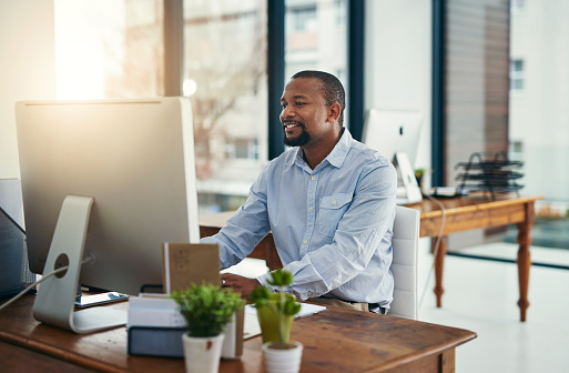 Cropped shot of a businessman working on a computer in an office