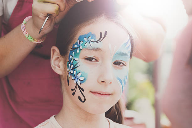 istock Female child face painting, making butterfly process 604000982