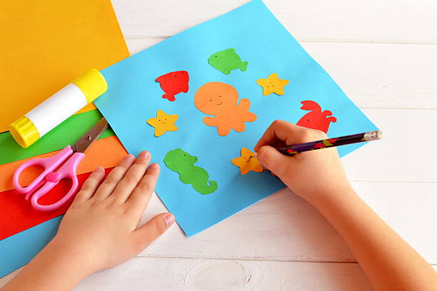 istock Child holds a pencil and draws 604001642