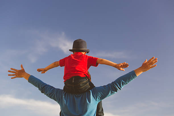 istock happy father and son playing on sky 604006528