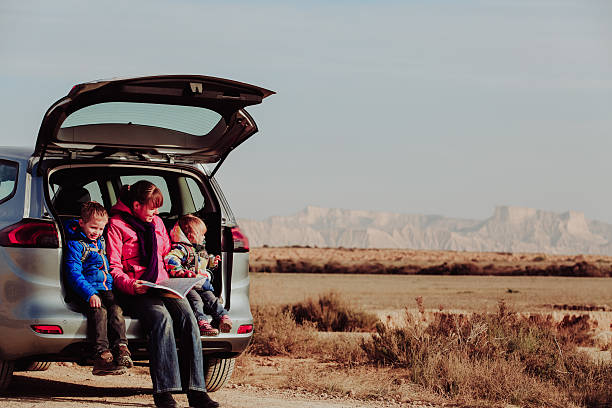 istock mother with kids looking at map while travel by car 604007332