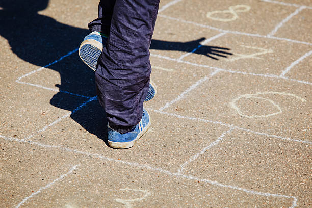 istock kid playing hopscotch on playground 604008528