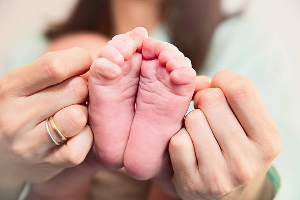 istock Mother holding her baby's feet 604008610