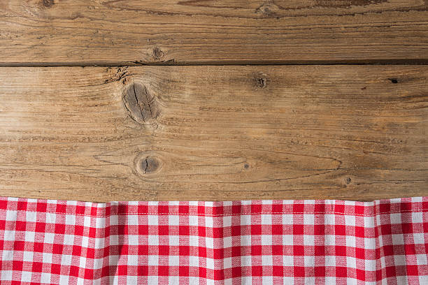 istock Checkered tablecloth red on the wooden background/ texture 604009062