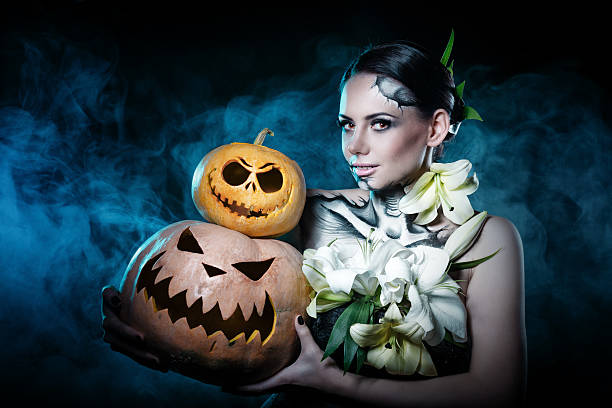 девушка с макияжем на хэллоуин. тыквы - make up women glamour horizontal стоковые фото и изображения