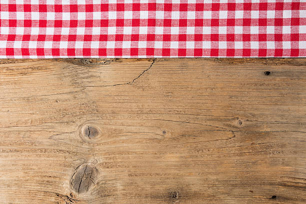 istock Checkered tablecloth red on the wooden background/ texture 604009208