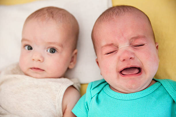 istock Twin boys head to head lying on bed 604009244