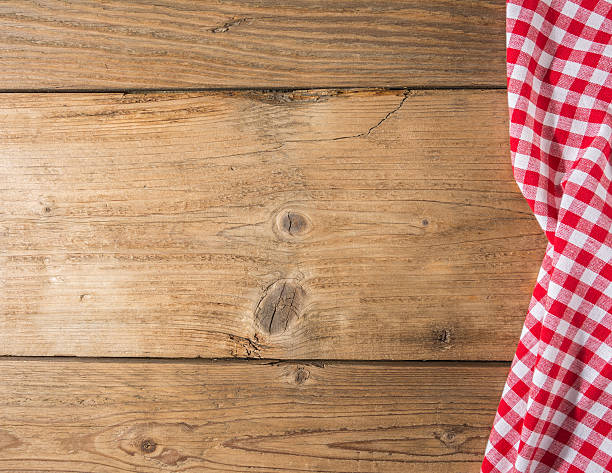 istock Checkered tablecloth red on the wooden background/ texture 604009492