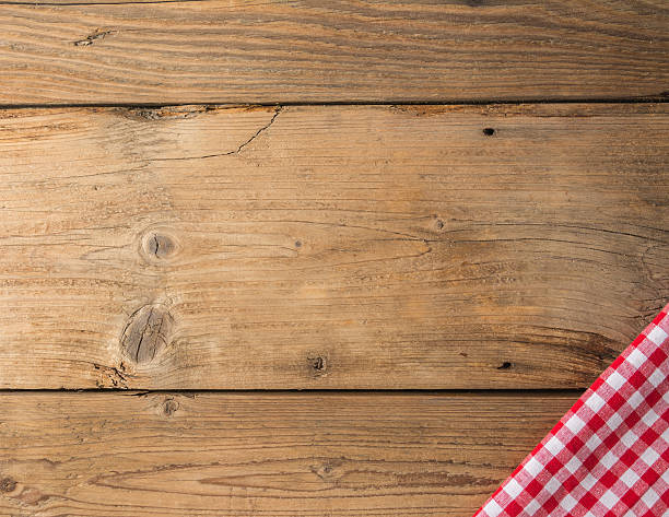 istock Checkered tablecloth red on the wooden background/ texture 604009746