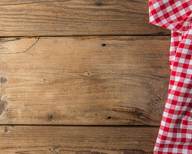 istock Checkered tablecloth red on the wooden background/ texture 604009862