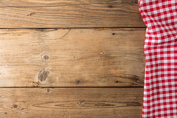 istock Checkered tablecloth red on the wooden background/ texture 604010038
