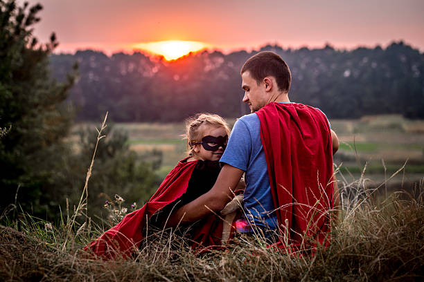 istock little girl with dad dressed in super heroes 604010070