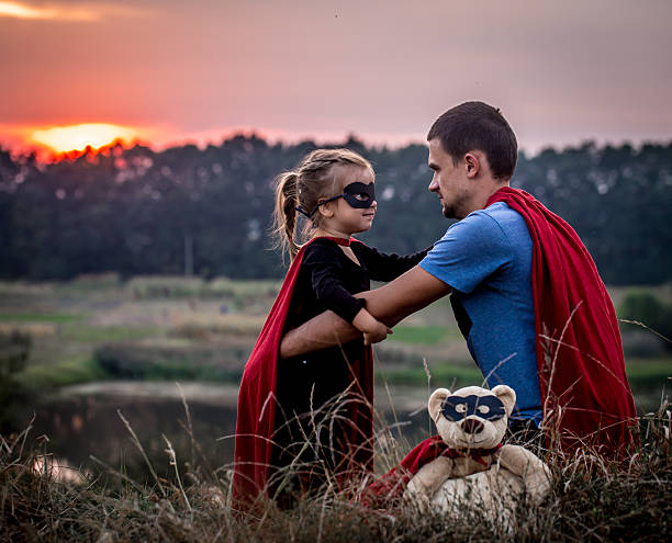istock little girl with dad dressed in super heroes 604010244