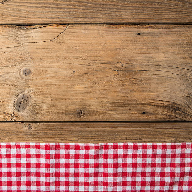 istock Checkered tablecloth red on the wooden background/ texture 604010406