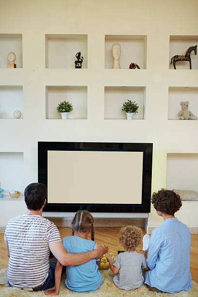 istock Watching tv in living room 604010912