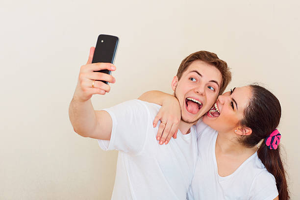istock Young couple doing selfie with your phone, smiling, laughing and 604011070