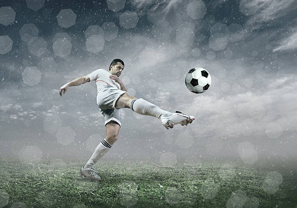 istock Football player with ball in action under sky with clouds 604012566
