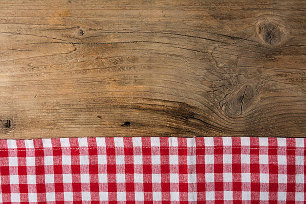 istock Checkered tablecloth red on the wooden background/ texture 604013710
