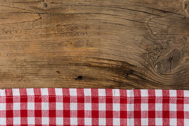 istock Checkered tablecloth red on the wooden background/ texture 604013862