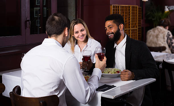 istock friends eating at restaurant table and chatting 604014712