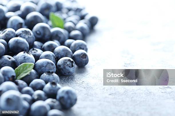 Ripe And Tasty Blueberries On Grey Wooden Table Stock Photo - Download Image Now - Antioxidant, Berry Fruit, Blue
