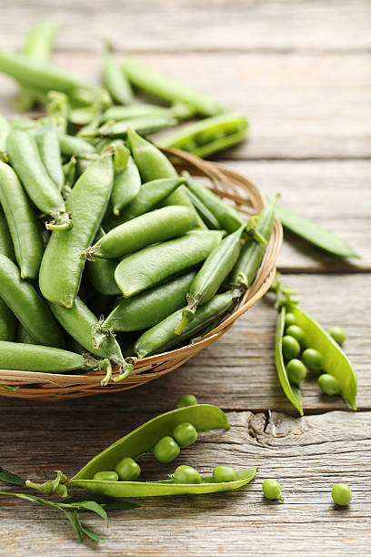 istock Green peas on a grey wooden table 604024568