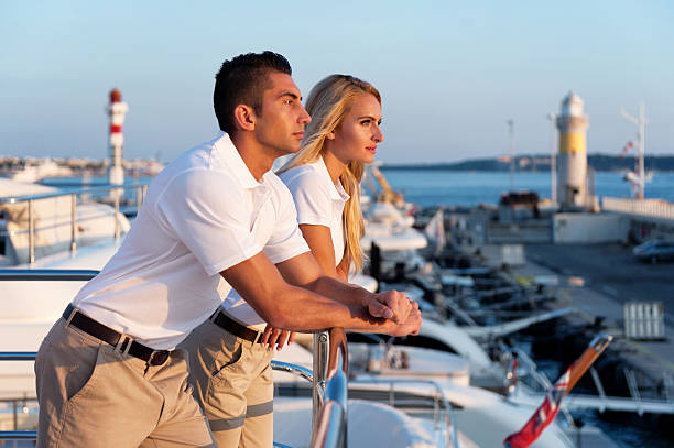 jeune couple profitant du coucher de soleil sur yacht - équipage de bateau photos et images de collection