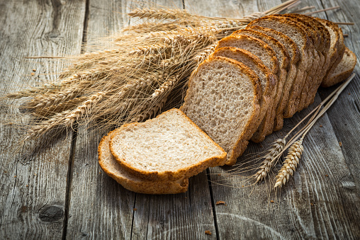 High resolution image of two integral rustic wholegrain brown bread slices, isolated on white background.