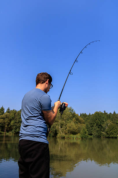 Young man fishing stock photo
