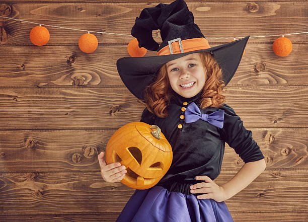 istock little witch with a pumpkin 604026750
