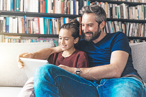 istock father and daughter having fun with digital tablet 604026958