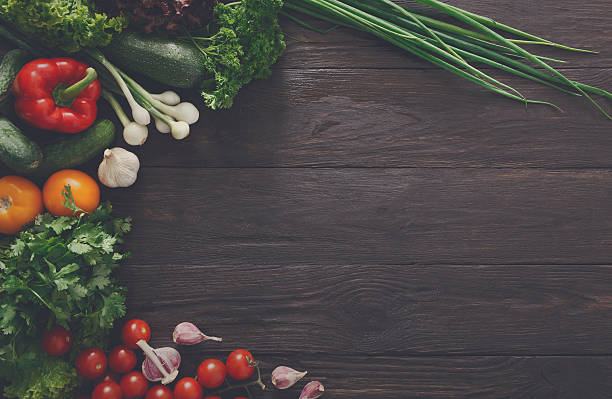 istock Border of fresh vegetables on wooden background with copy space 604029040