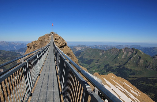 Scene on the Sex Rouge, Swiss Alps. Suspension bridge connecting two mountain peaks. Popular travel destination. 