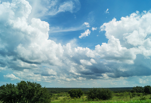 Texas landscape in the western part of the state (west Texas) including clouds, sky, trees, shrubs and wide shot